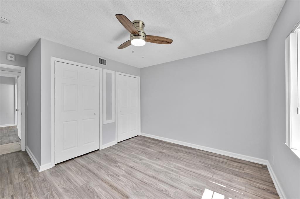 7541 Northwest 16th Street, Unit 1211 Plantation, FL 33313 - Photo 8 of 23 an empty room with wooden floor fan and windows