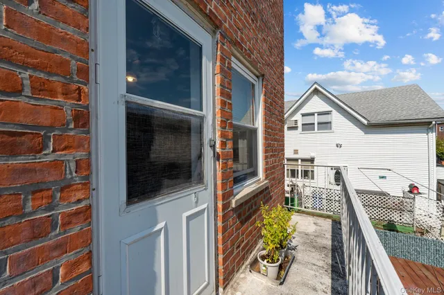 a view of a balcony with chairs and a barbeque