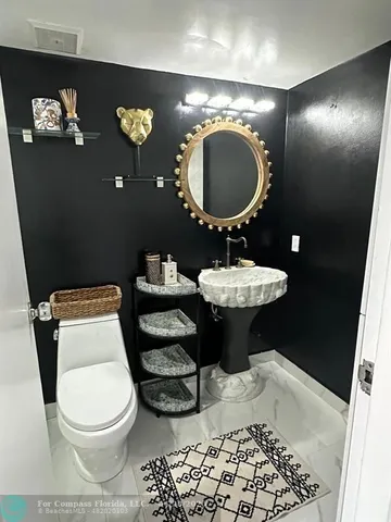 a bathroom with a toilet a sink and mirror