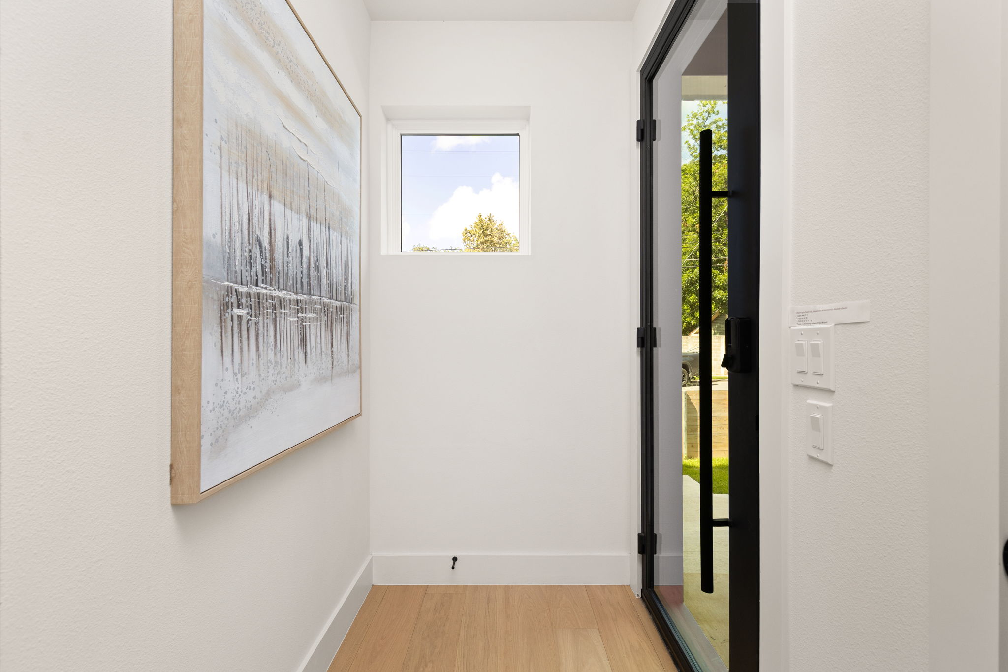 732 Springdale Road, Unit A Austin, TX 78702 - Photo 4 of 18 Blonde hardwood floors extend from the glass entry door into a bright, naturally illuminated foyer.