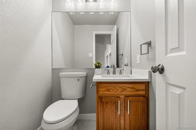 a bathroom with a toilet a sink and mirror