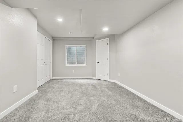 an empty room with windows and closet