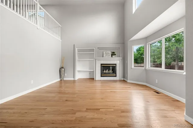 a view of an empty room with a window and fireplace