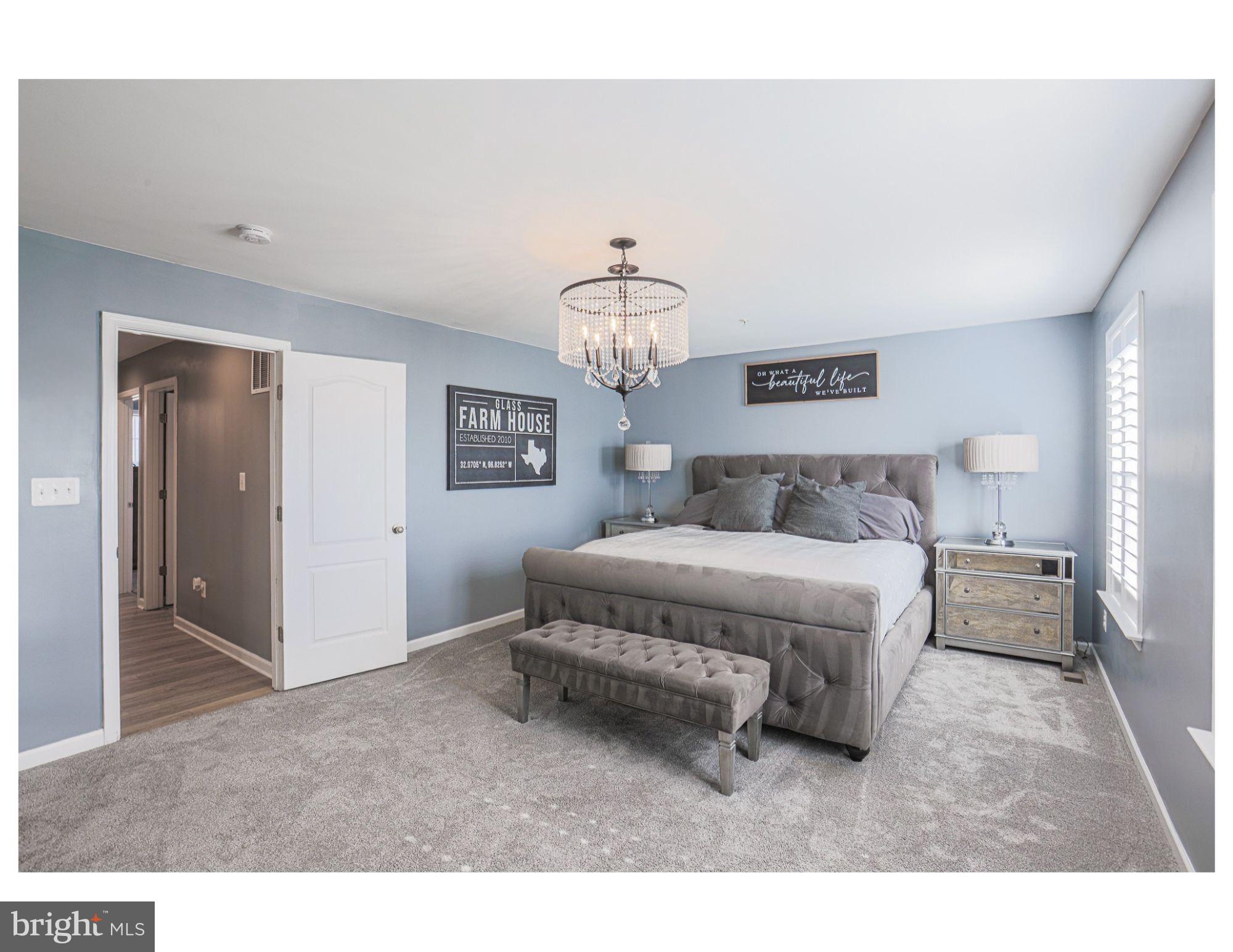 809 Jefferson Pike Brunswick, MD 21716 - Photo 35 of 64 a spacious bedroom with a bed and a chandelier