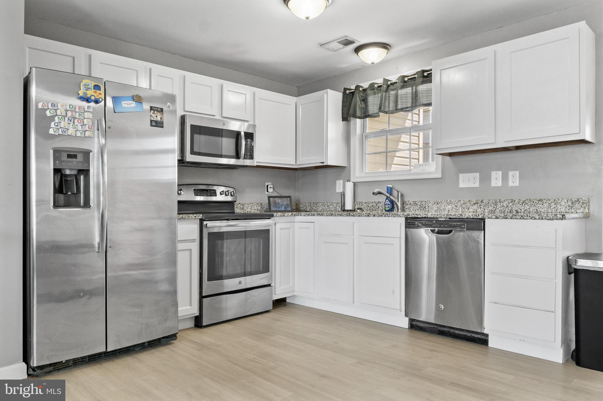 39 Baltic Court Inwood, WV 25428 - Photo 2 of 17 a kitchen with stainless steel appliances granite countertop a refrigerator and a stove top oven