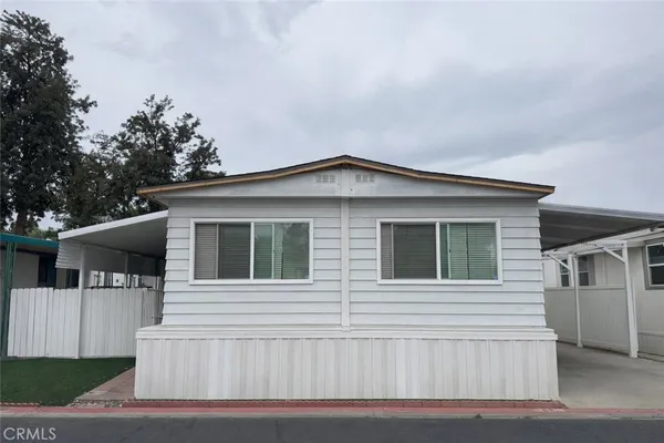 a view of a house with a small yard and wooden fence