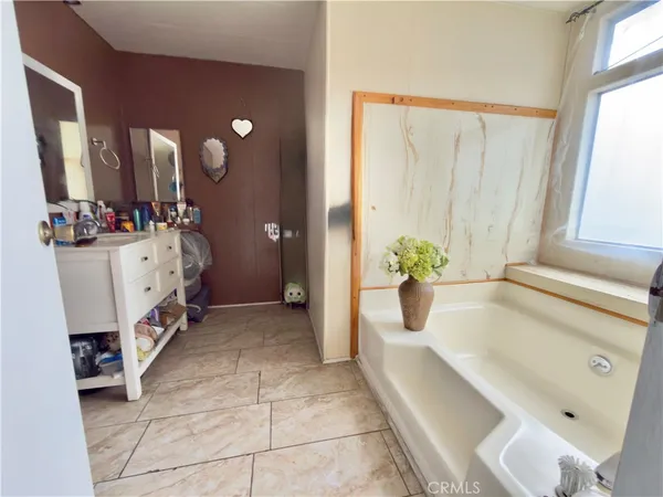 a spacious en suite bathroom with a tub sink and mirror