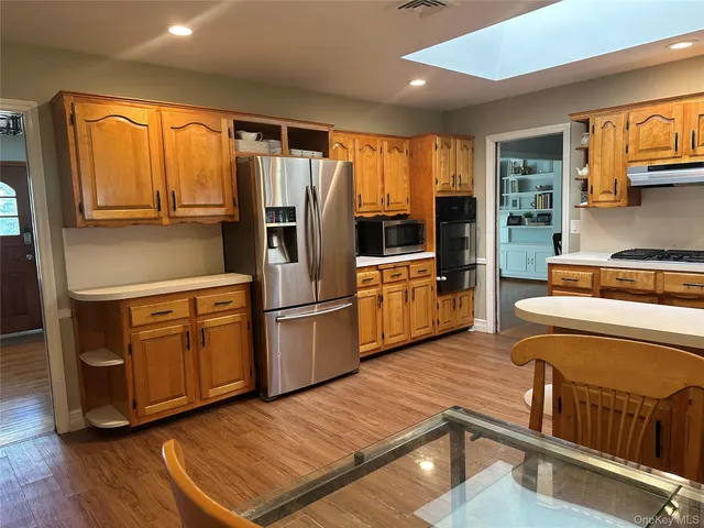 a kitchen with stainless steel appliances granite countertop a refrigerator a stove and a sink