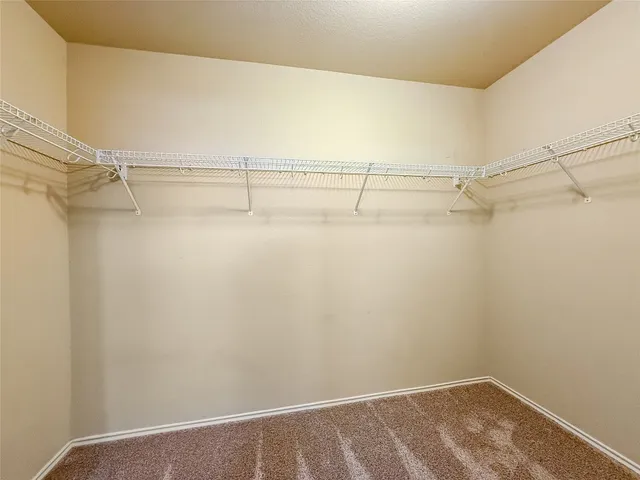 an empty room with a window and a ceiling fan