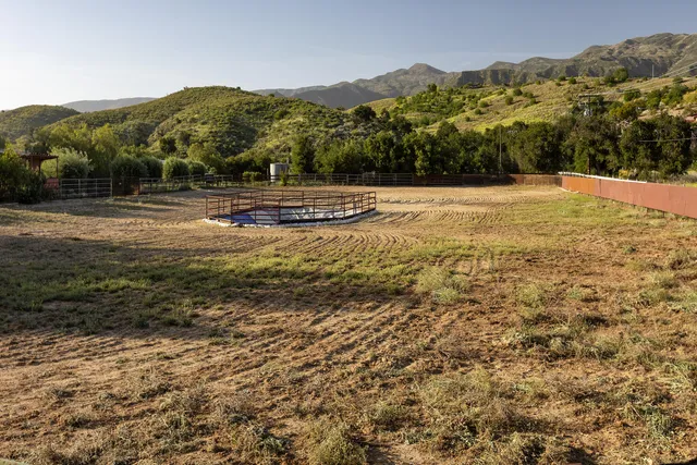 a spacious bedroom with a balcony a bed and wooden floor