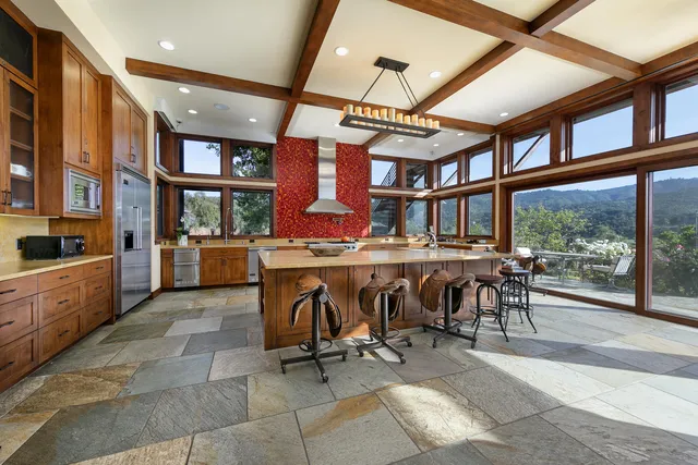 a kitchen with a stove kitchen island furniture and a large window