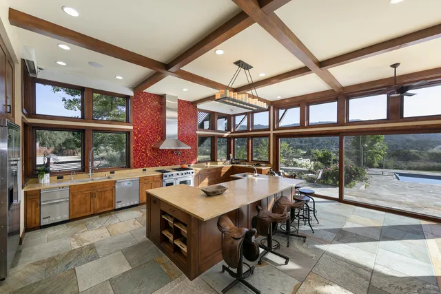 a living room with fireplace furniture and a large window