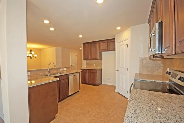 a kitchen with stainless steel appliances granite countertop a sink stove and refrigerator