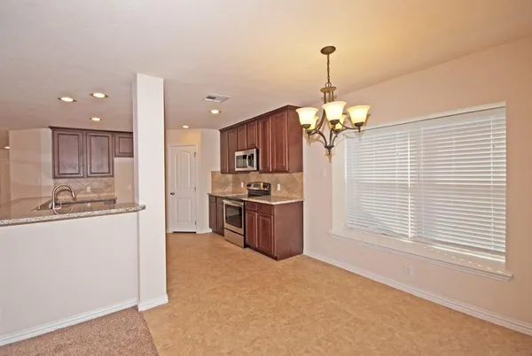 a kitchen with stainless steel appliances kitchen island granite countertop a stove and a refrigerator