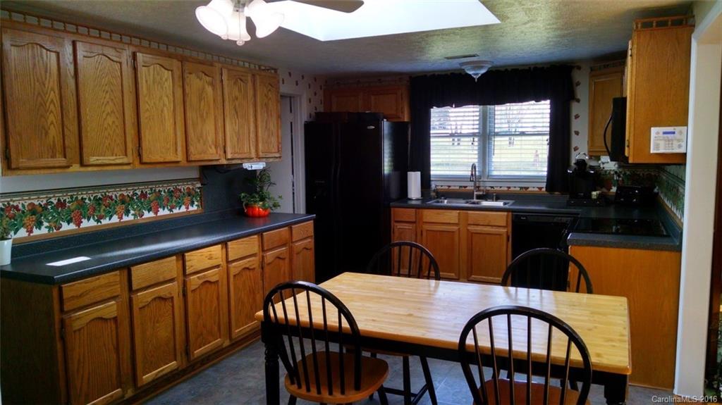 1978 Ridge Road Hendersonville, NC 28792 - Photo 2 of 18 a kitchen with granite countertop lots of wooden cabinets stainless steel appliances a sink and a window