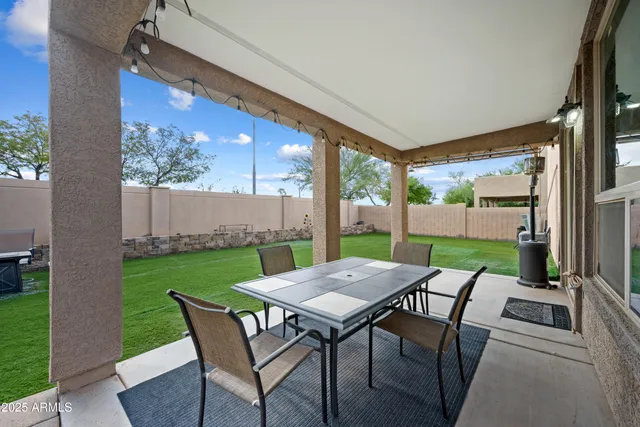 a view of a patio with a table chairs and a backyard