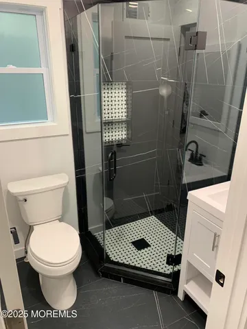 a bathroom with a toilet and a shower