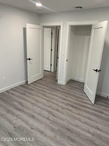 an empty room with wooden floor and closet