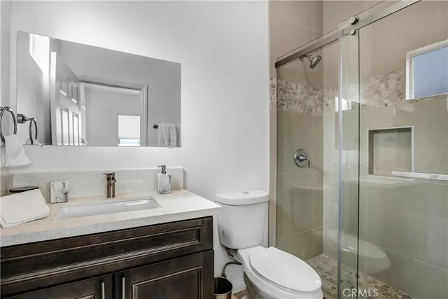 a bathroom with a sink a toilet and shower