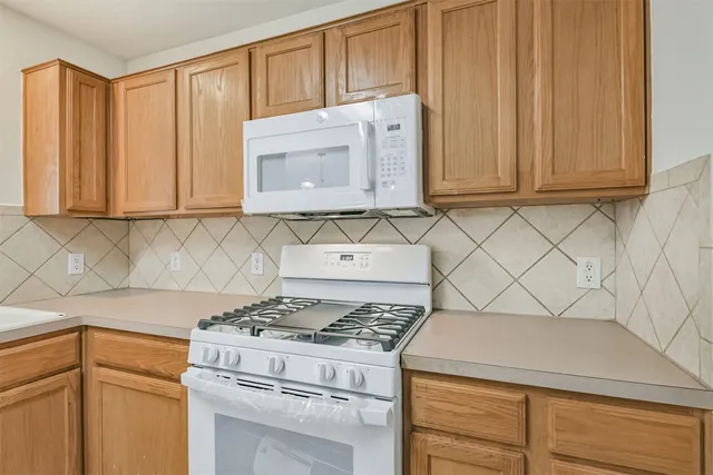 a kitchen with granite countertop cabinets and a stove top oven