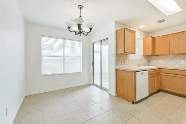 a kitchen with kitchen island granite countertop a sink cabinets and window