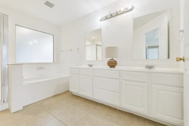 a bathroom with a tub sink and mirror