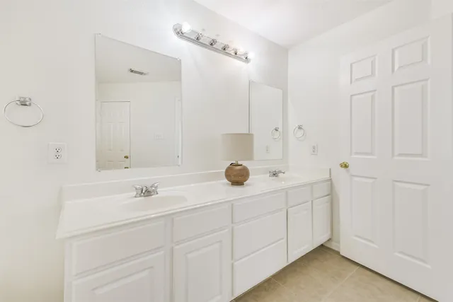 a bathroom with double sink and mirror