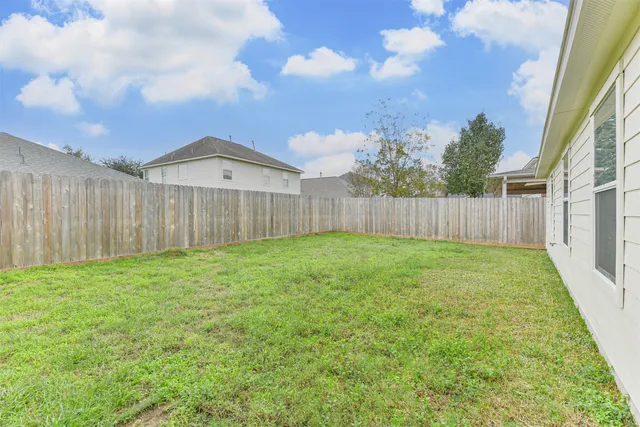a view of a backyard with wooden fence