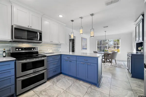 a kitchen with stainless steel appliances granite countertop a stove a sink and a microwave