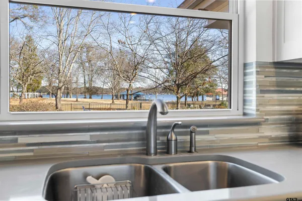 a view of a sink with a floor to ceiling window and outside view