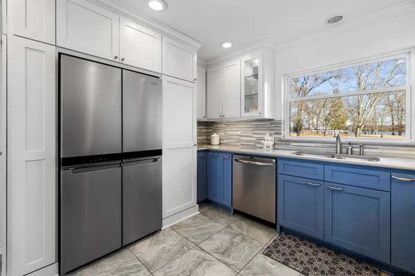 a kitchen with stainless steel appliances granite countertop a refrigerator a sink and a cabinets