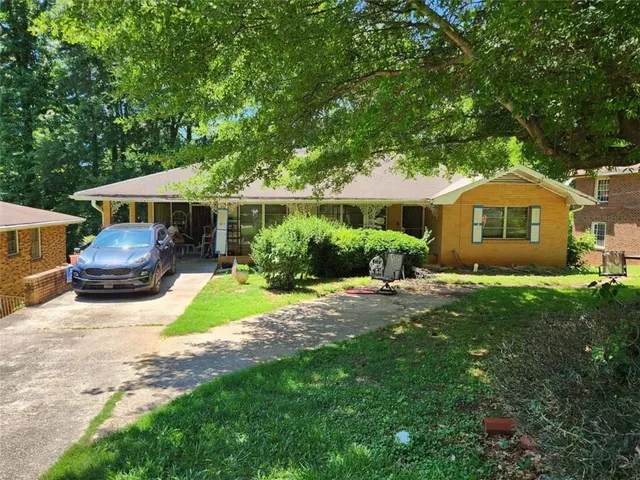 a car parked in front of a house next to a yard