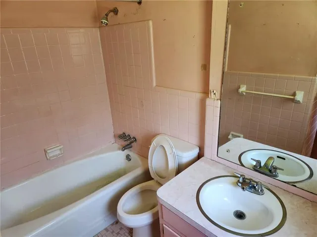 a bathroom with a sink toilet mirror vanity and shower