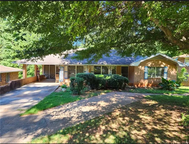 a front view of a house with a yard and potted plants