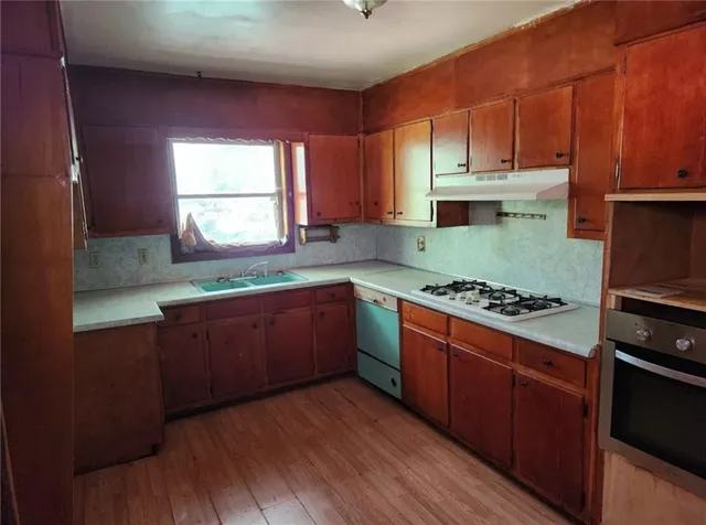 a kitchen with stainless steel appliances granite countertop a stove a sink and a refrigerator