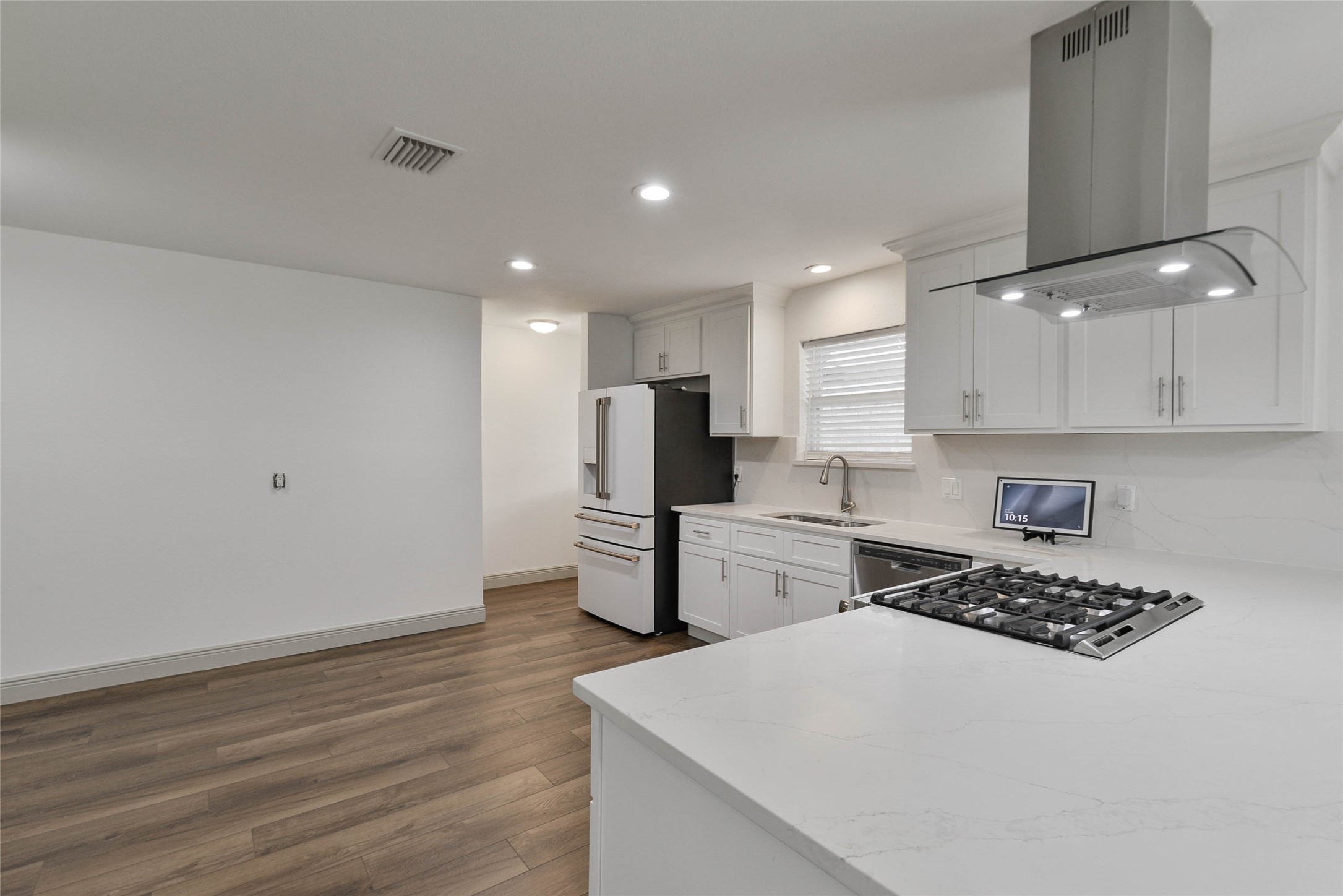 531 Brandon Road Conroe, TX 77302 - Photo 24 of 33 a kitchen with stainless steel appliances a refrigerator oven a sink dishwasher and white cabinets with wooden floor