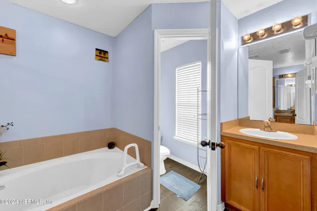 a bathroom with a tub sink and mirror