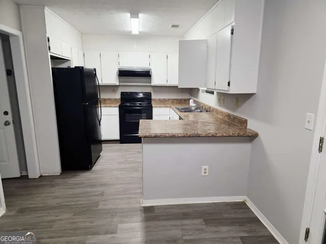 a kitchen with a refrigerator and a stove top oven