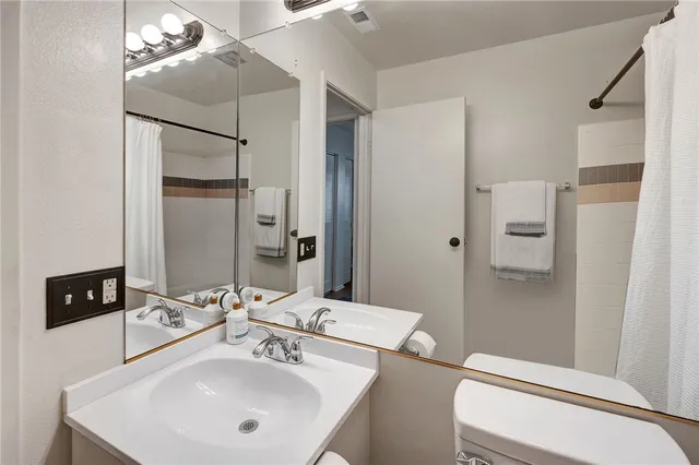 a bathroom with a sink and mirror with toilet