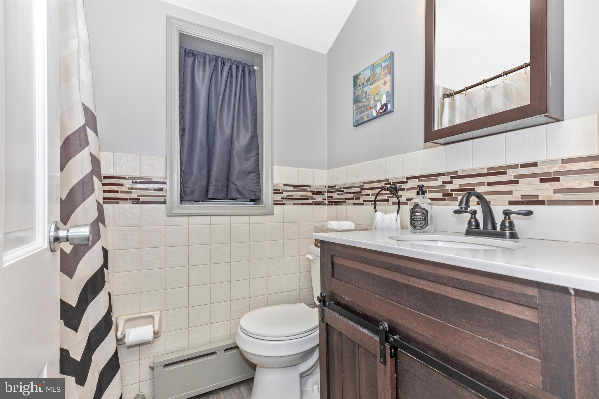 1432 Burmont Road Havertown, PA 19083 - Photo 20 of 28 a bathroom with a sink a toilet and a mirror