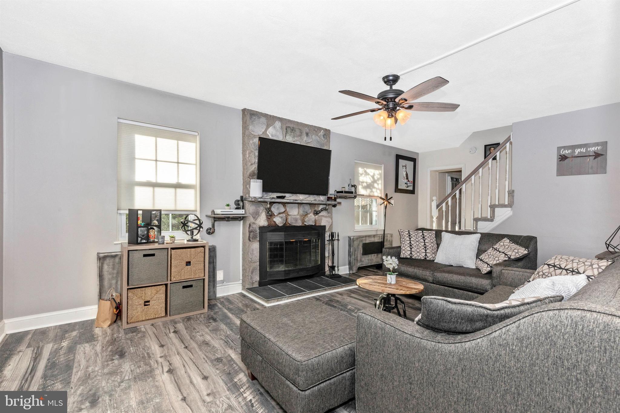 1432 Burmont Road Havertown, PA 19083 - Photo 3 of 28 a living room with furniture a fireplace and a flat screen tv
