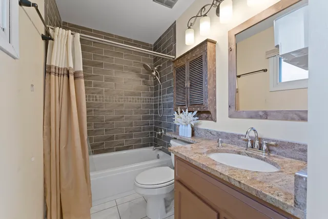 a bathroom with a granite countertop sink toilet and shower