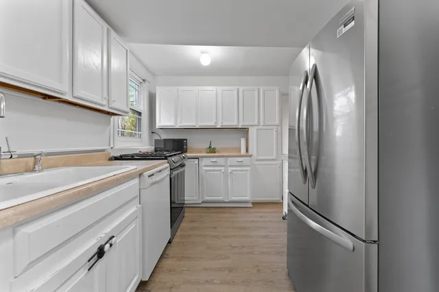 a kitchen with a refrigerator sink and cabinets