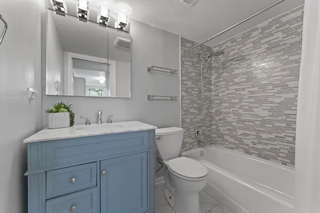 a bathroom with a granite countertop sink toilet and shower