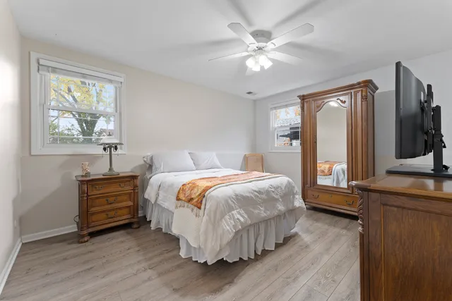 a bedroom with a bed and a flat tv screen on dresser