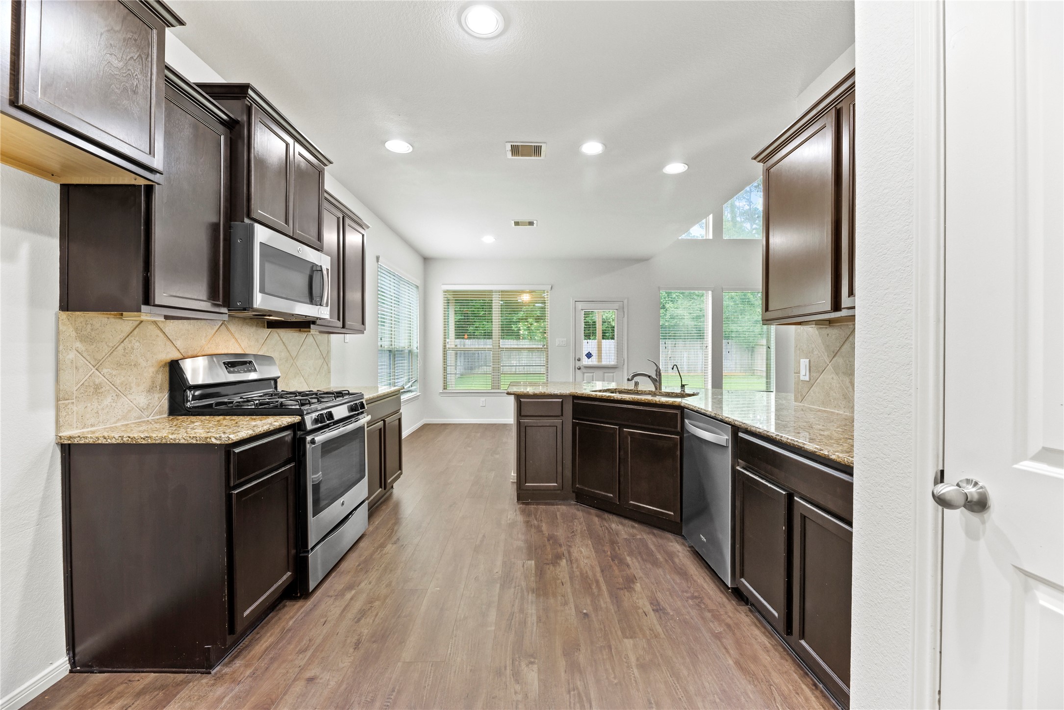 22514 Forbes Field Trail Spring, TX 77389 - Photo 12 of 37 a kitchen with stainless steel appliances granite countertop lots of counter top space a stove and wooden floors