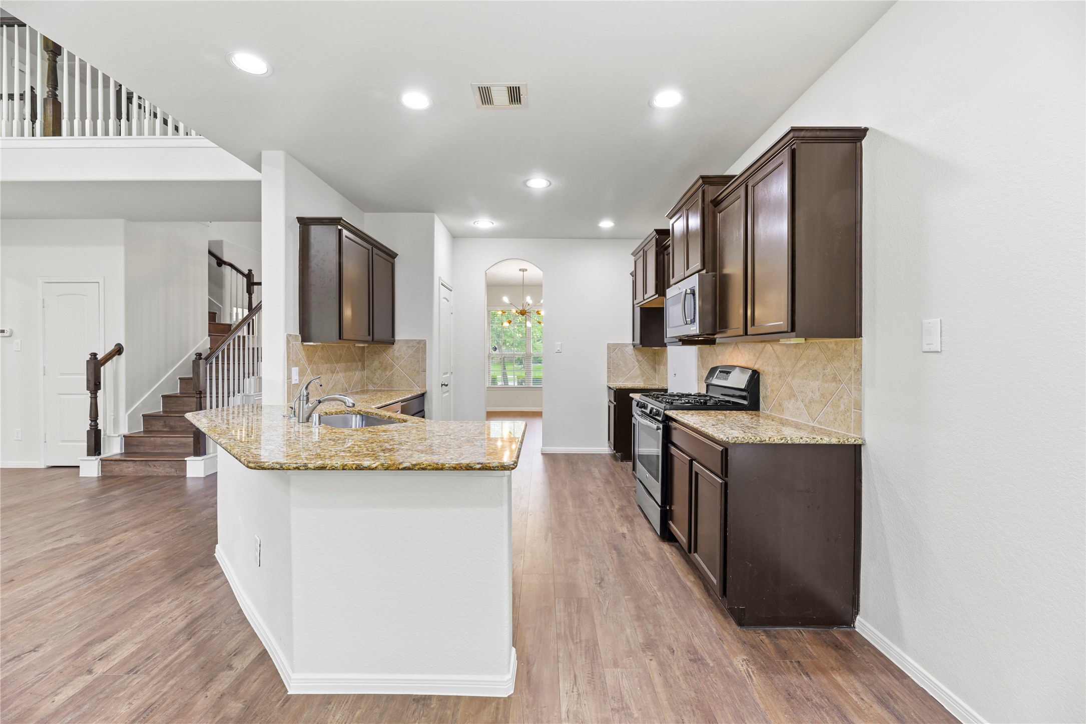 22514 Forbes Field Trail Spring, TX 77389 - Photo 10 of 37 a kitchen with kitchen island stainless steel appliances a sink wooden floor and counter top space