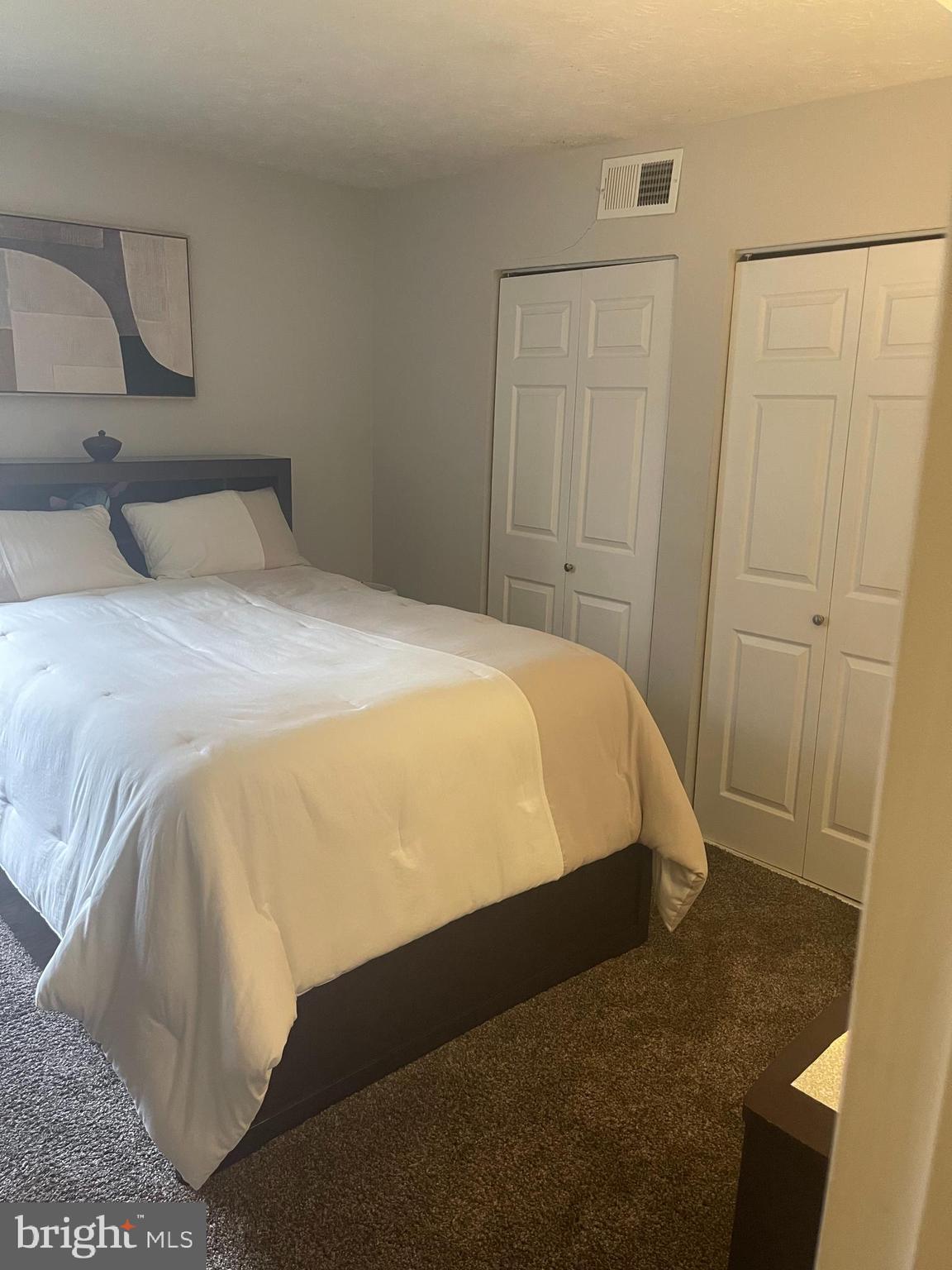 8015 Mandan Road, Unit 202 Greenbelt, MD 20770 - Photo 40 of 52 a bed sitting in a bedroom next to a bathroom