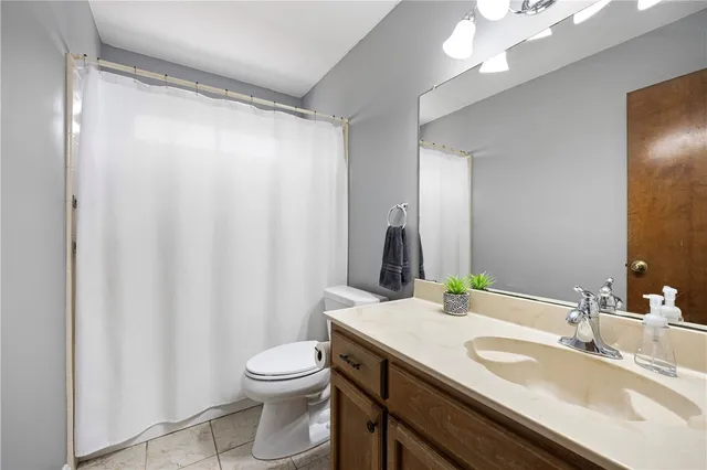 a bathroom with a granite countertop sink toilet and a mirror
