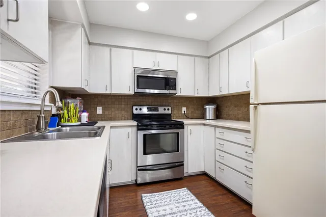 a kitchen with a refrigerator stove and white cabinets